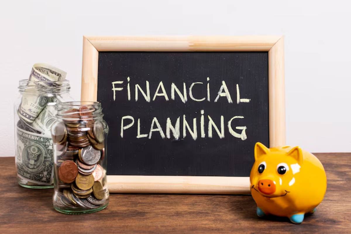  Chalkboard displaying Financial Planning with jars of coins and cash, alongside a yellow piggy bank on a wooden surface.