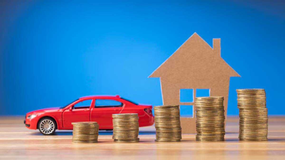  A red toy car next to stacks of coins, with a cardboard house in the background, against a blue backdrop, symbolizing financial planning.